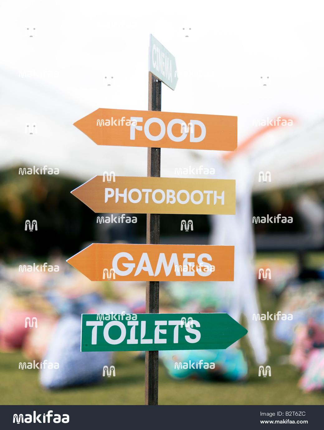Panneaux directionnels vers les stands de nourriture, les jeux et les toilettes.