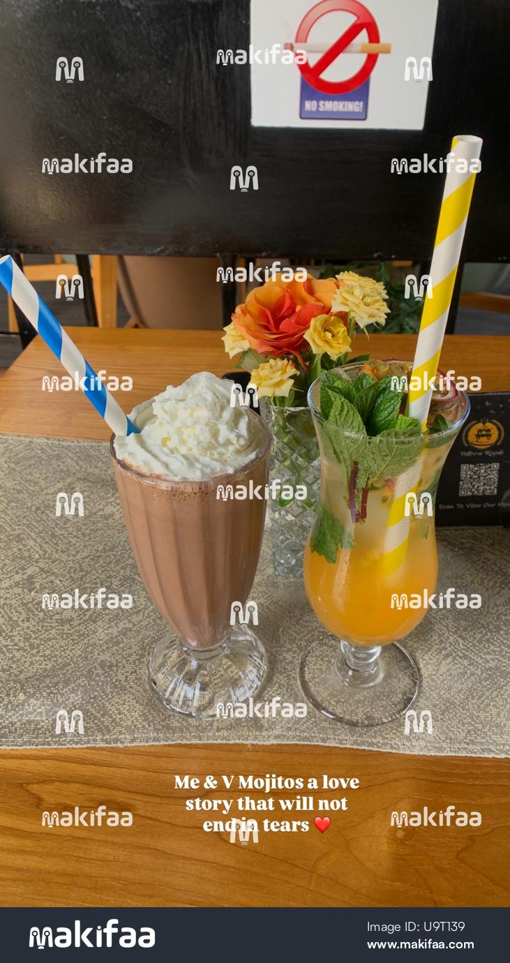 Batido de chocolate y cóctel tropical servidos en la mesa de la cafetería.