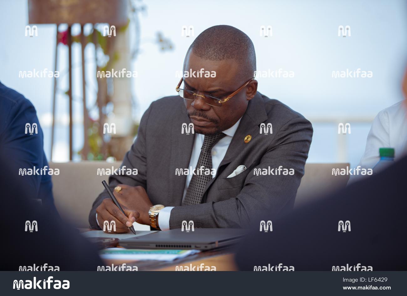 Hombre tomando notas en un cuaderno durante una sesión de trabajo, conferencia 
