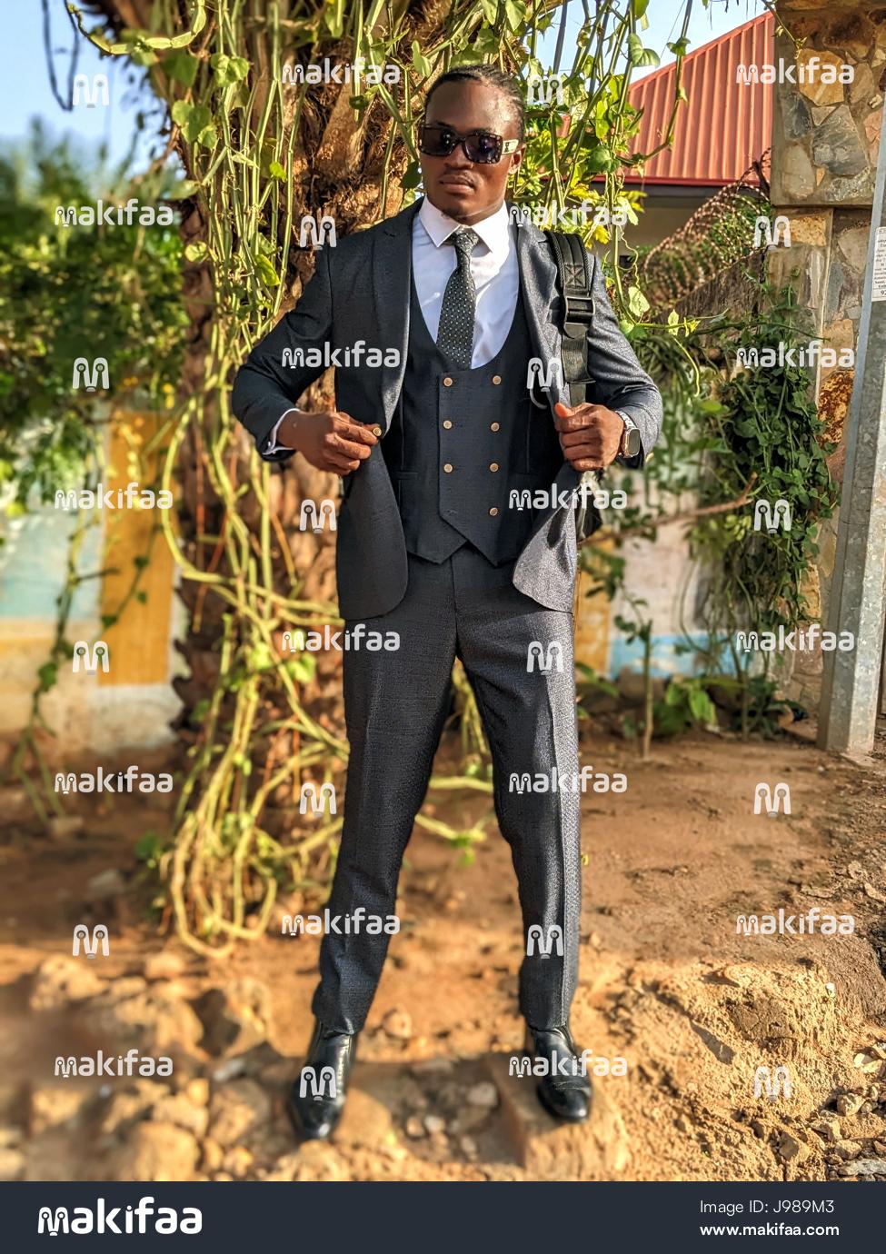 Retrato de um homem elegante de terno e óculos escuros.