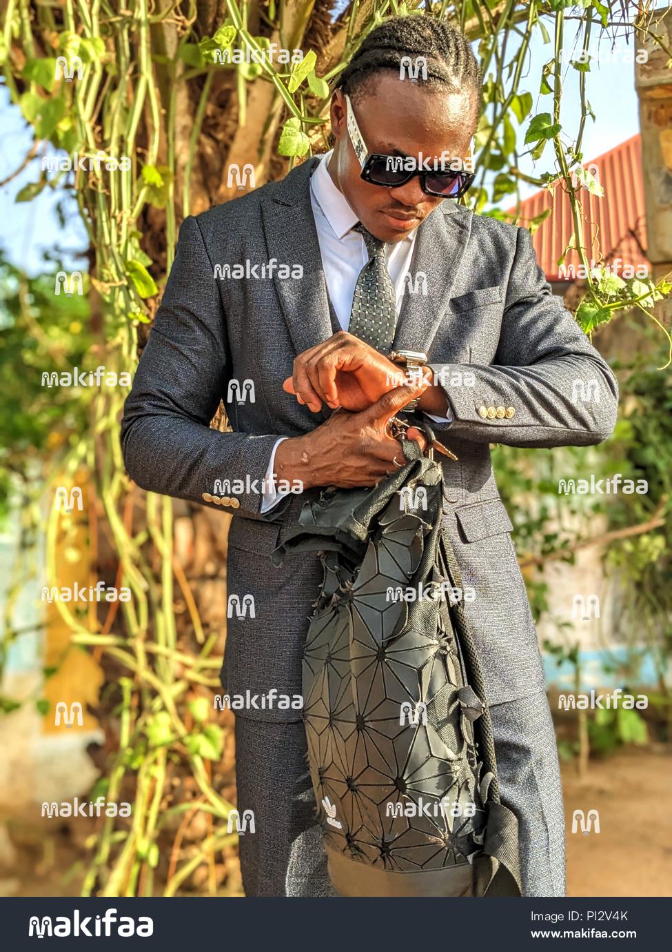 Um jovem elegante conferindo seu relógio.