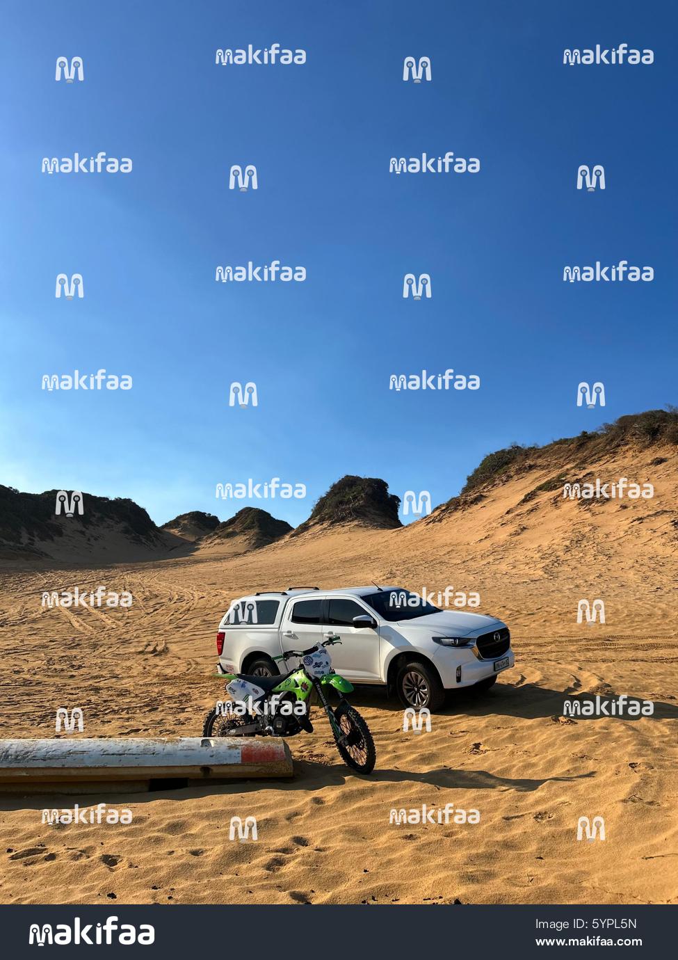 Car and motorcycle parked in sand Beach vibes