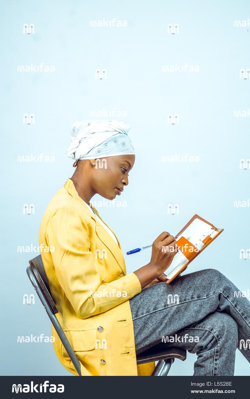 Hermosa estudiante sentada escribiendo en un cuaderno