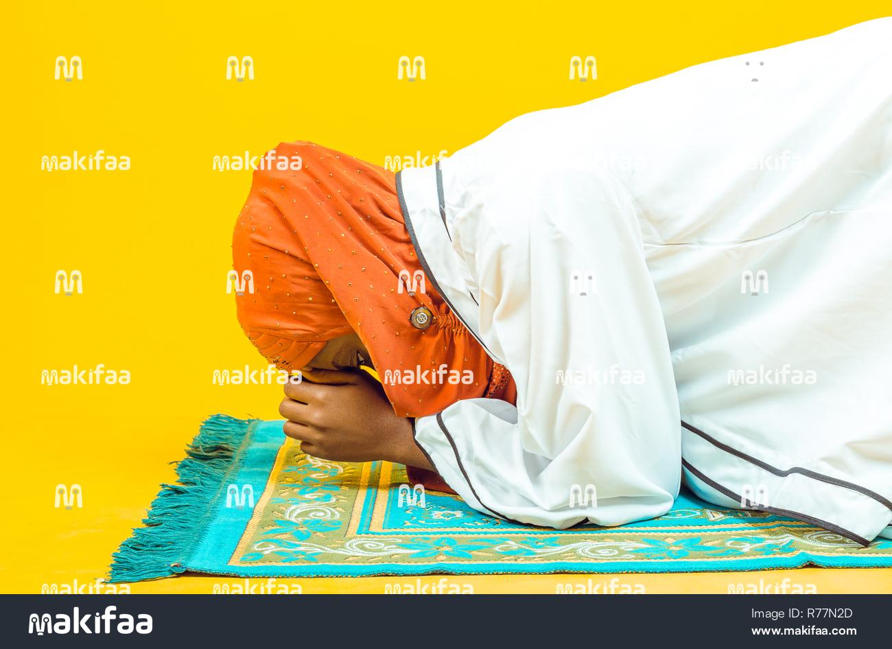 Hermosa joven musulmana rezando sobre una estera