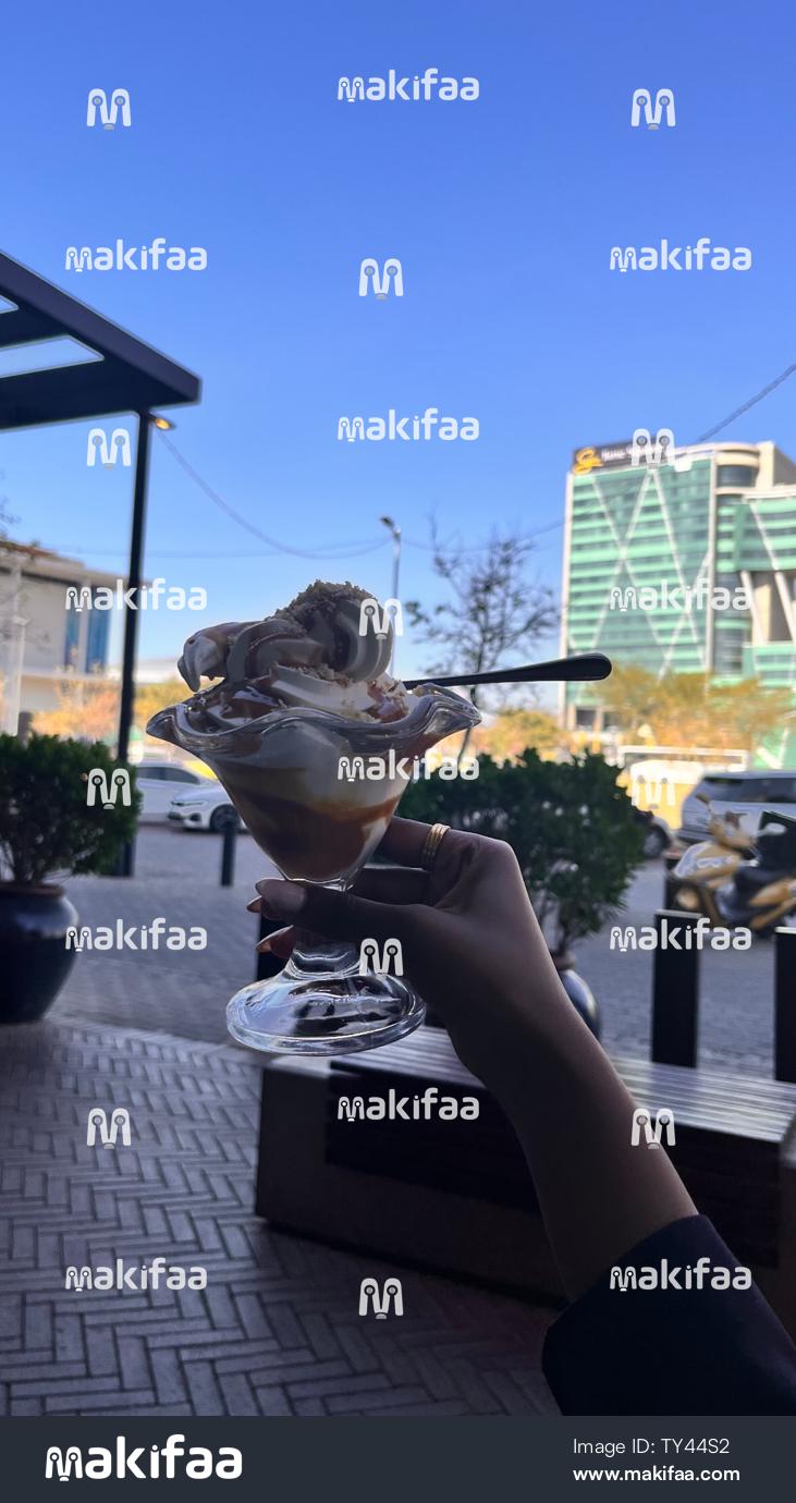 Mano sosteniendo un helado en la cafetería