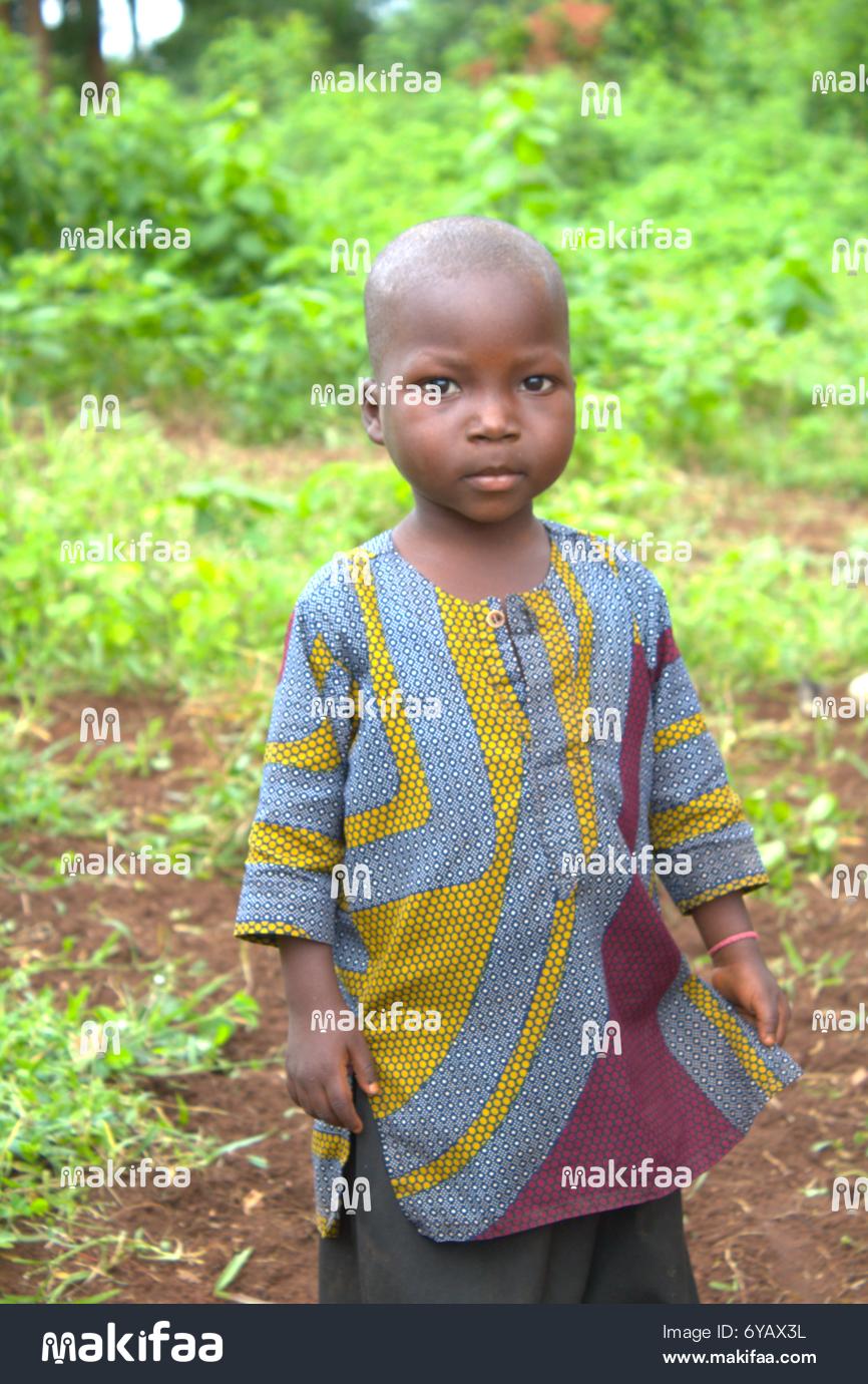 Portrait d’un enfant africain en boubou coloré, fond végétal