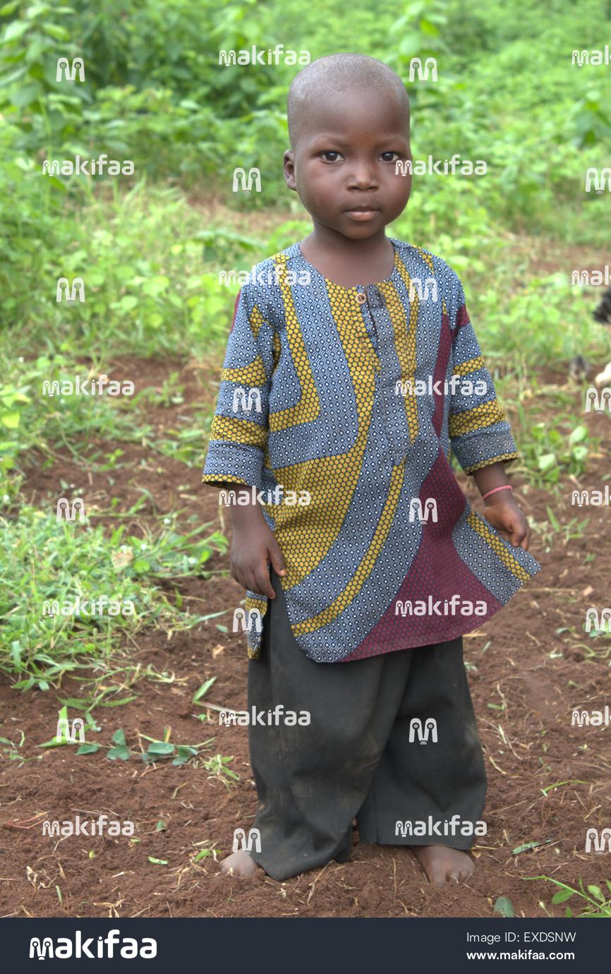 Criança africana em cera boubou colorida em um campo verde