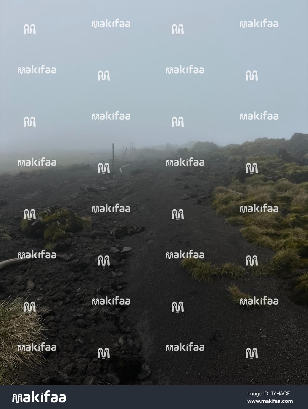 Fog above volcanoes with rugged lava stones 