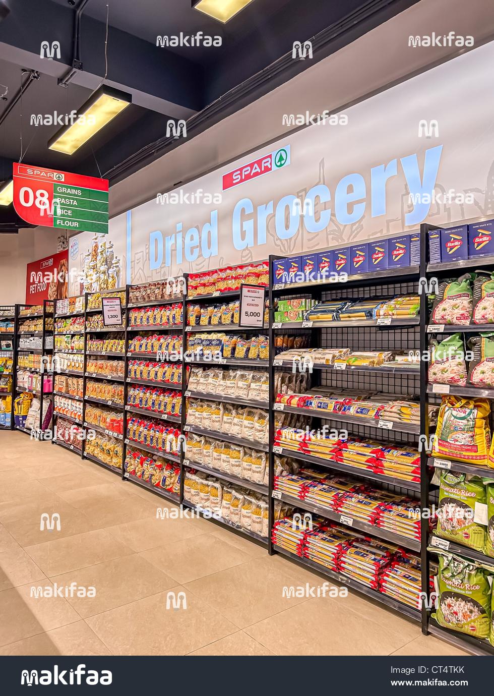 Una amplia selección de espaguetis y arroz exhibidos en un supermercado.