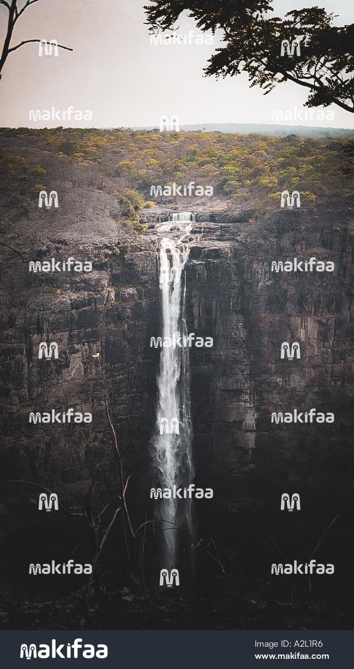 Waterfall cascading down a rocky cliff surrounded by forest