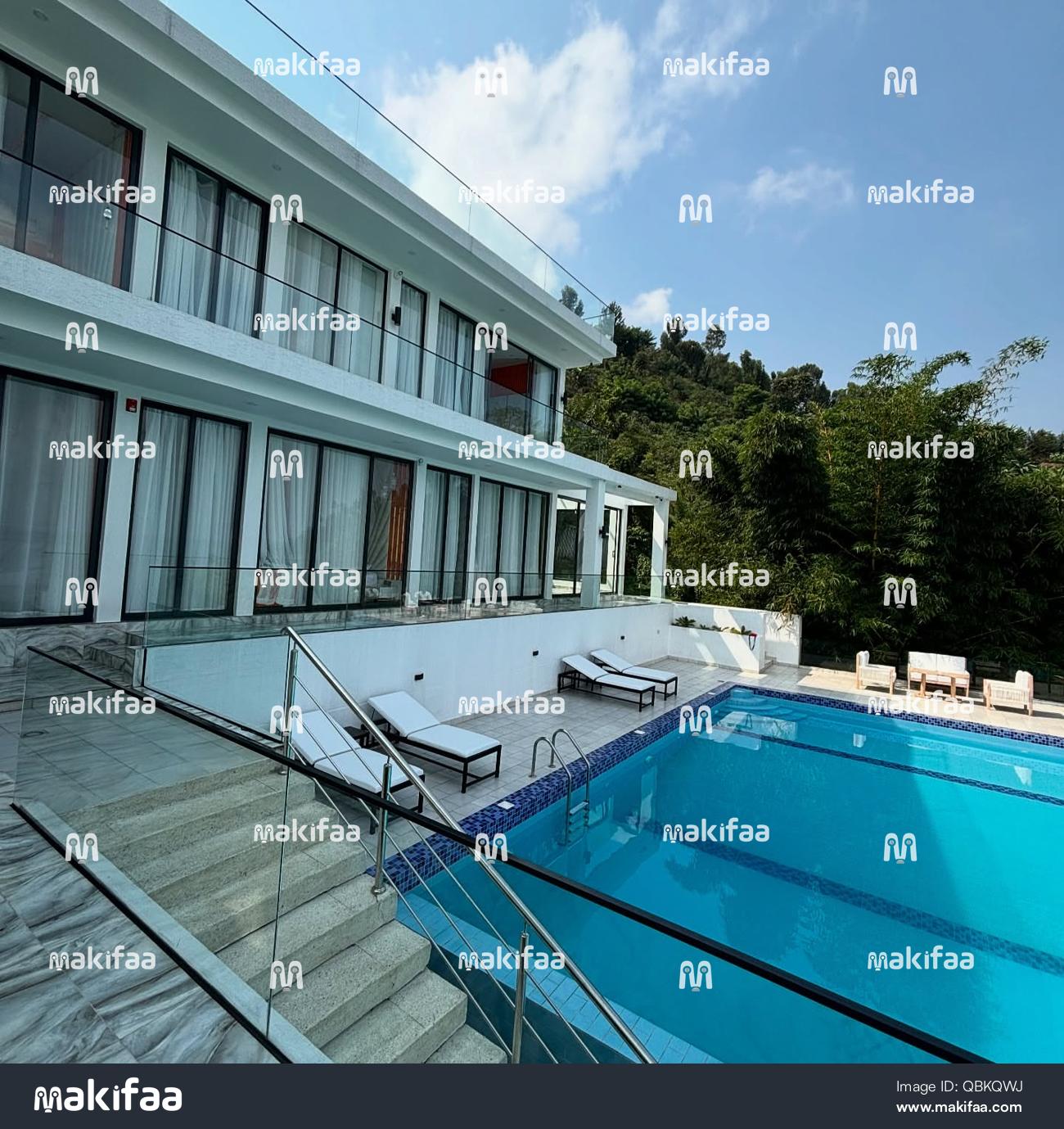 Vue extérieure d'une villa avec une piscine entourée de végétation