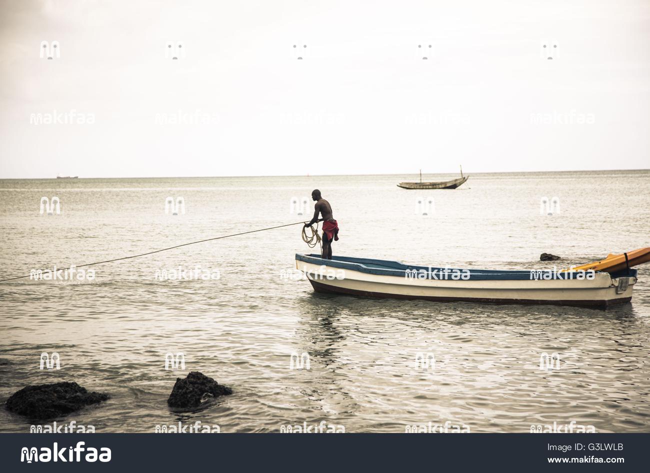pescador no meio do mar em pé em uma canoa 
