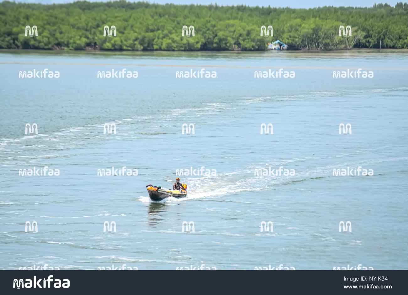 Um homem em uma lancha atravessando um canal. 