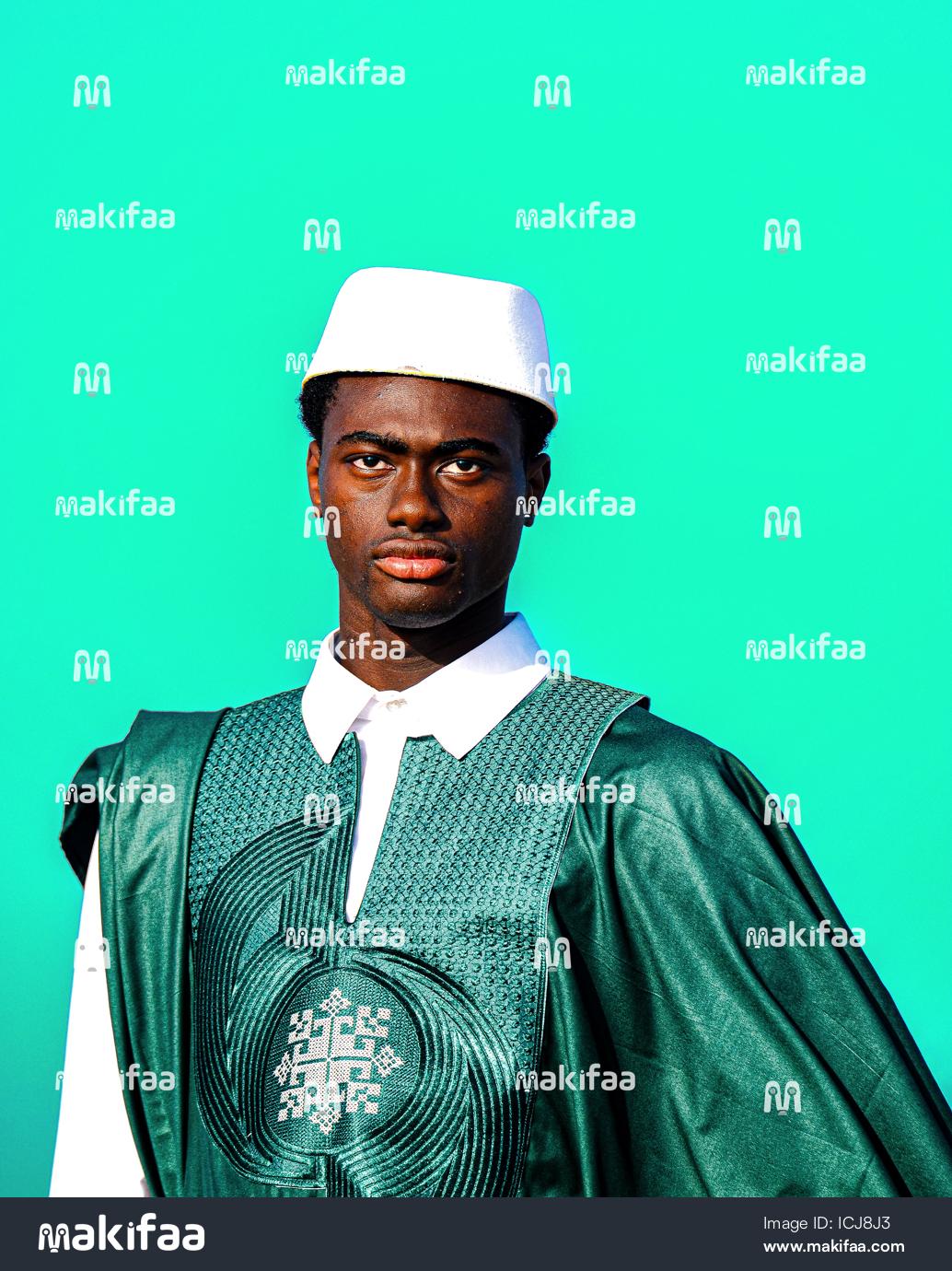 Studio portrait of a young man in a traditional green boubou 