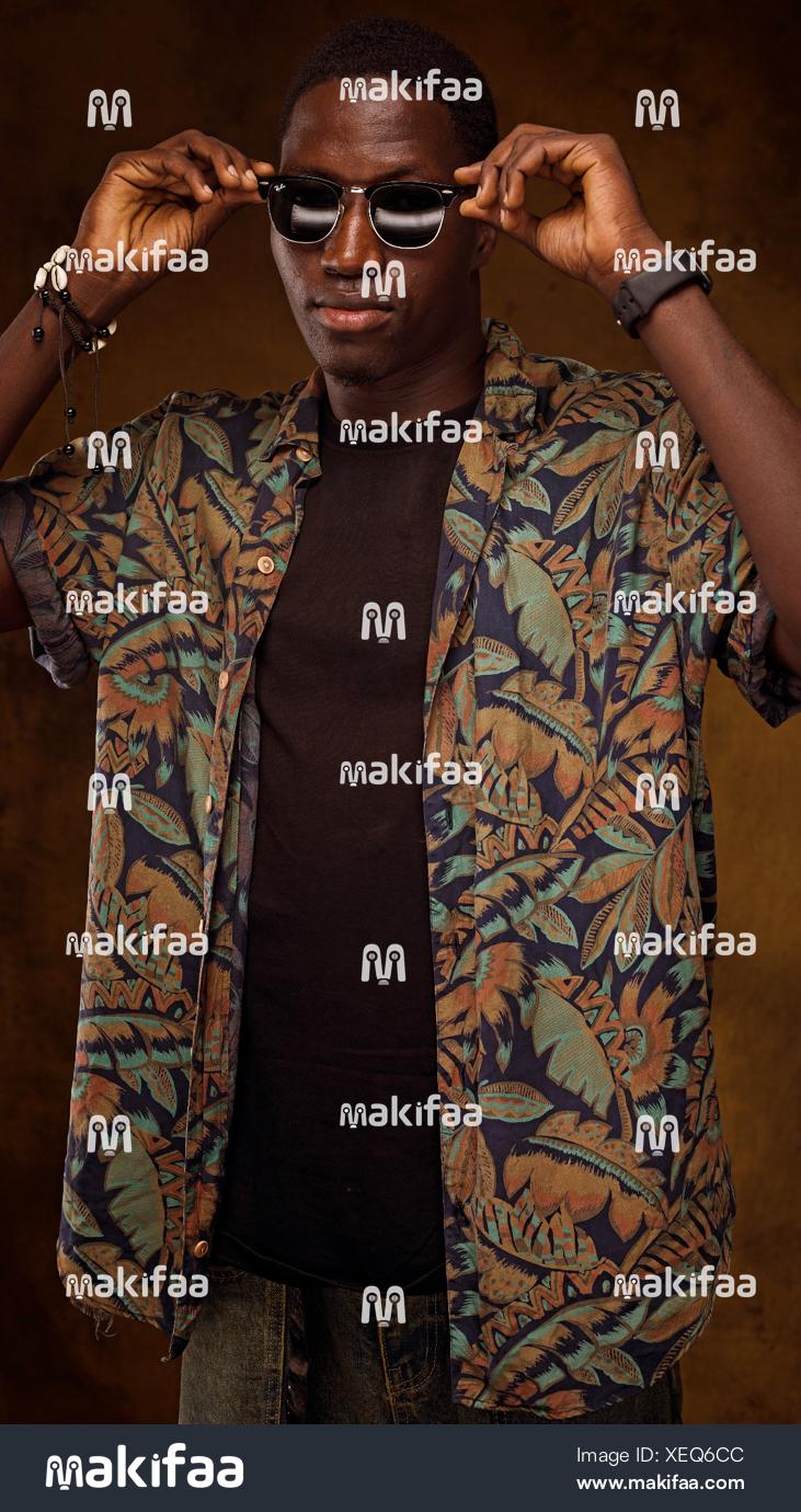 Young man adjusting his sunglasses