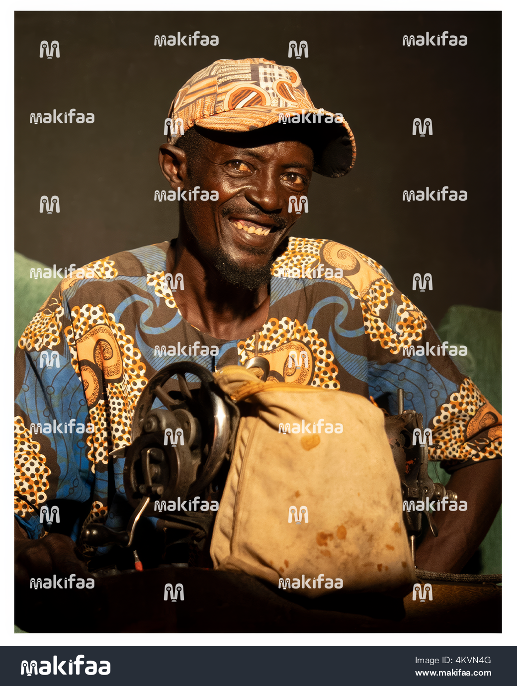 Mwanaume akitabasamu mbele ya cherehani yake 