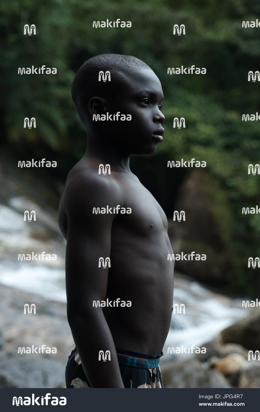 A young man at the water&#39;s edge in a tropical area 