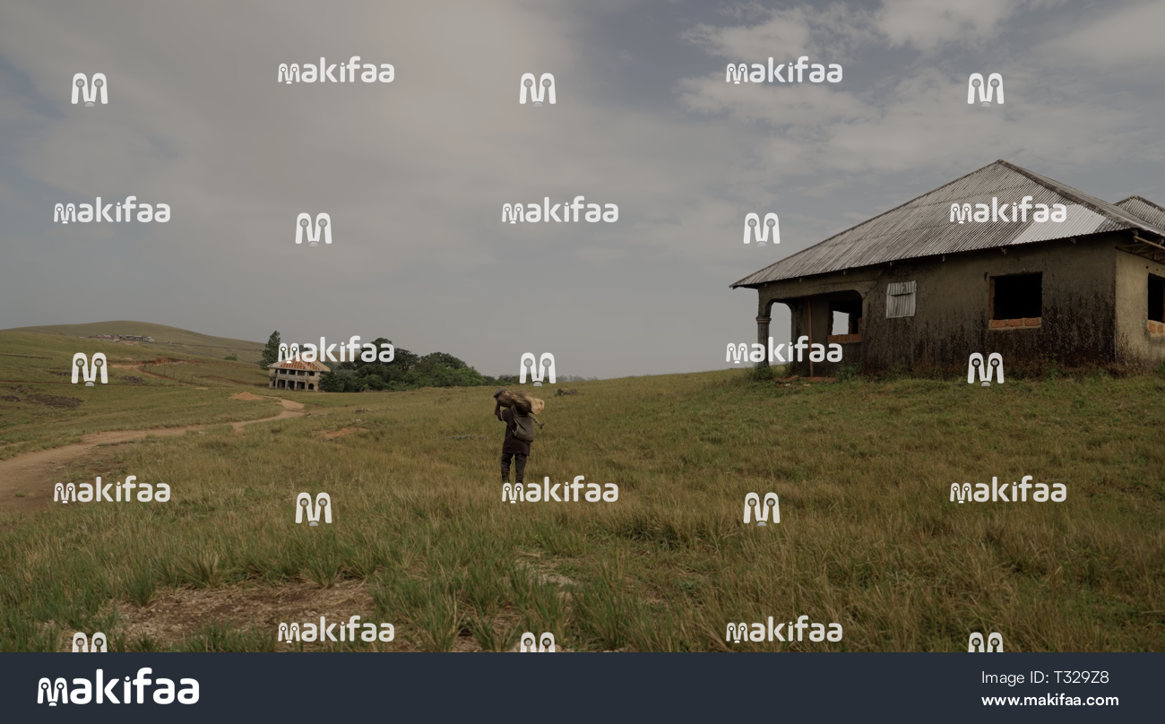A person walks towards a rural house 