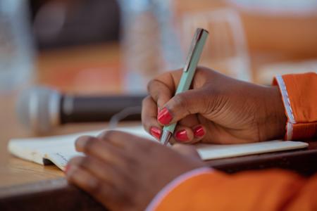 Mano de mujer sosteniendo un bolígrafo escribiendo en un cuaderno 