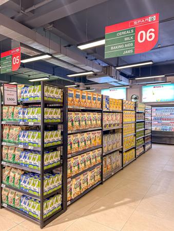 Una colorida sección de supermercado de leche, cereales y mermeladas.