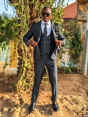 Retrato de um homem elegante de terno e óculos escuros.