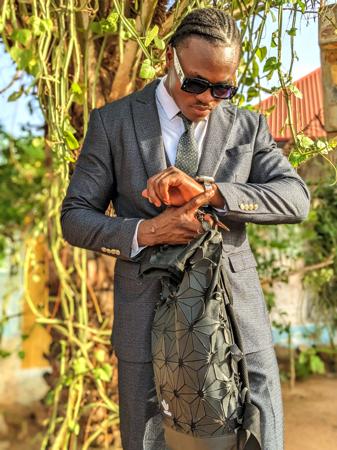 Um jovem elegante conferindo seu relógio.