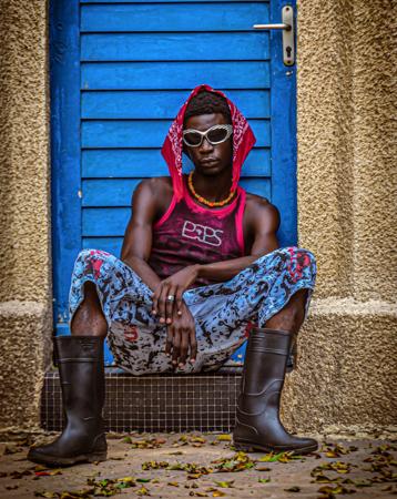Stylish portrait of a young man sitting in a swag style