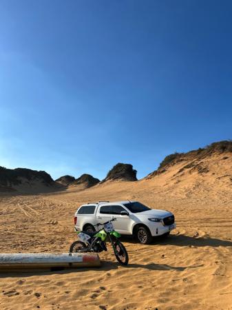 Car and motorcycle parked in sand Beach vibes