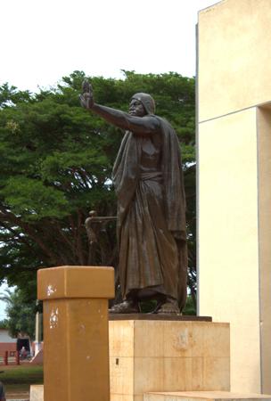 Estátua de Behanzin de um chefe africano saudando, vista lateral