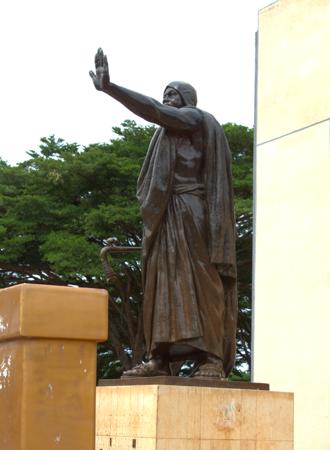 Behanzin Estátua monumental de um líder africano levantando a mão em sinal de autoridade