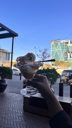 Mano sosteniendo un helado en la cafetería
