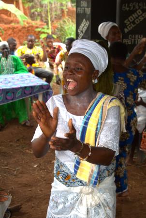  Mulher africana cantando e batendo palmas em uma cerimônia em uma aldeia