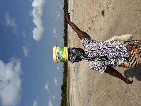 A woman walking with a bucket on her head