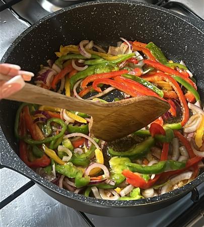 Fresh green and red peppers sizzle in hot cooking oil
