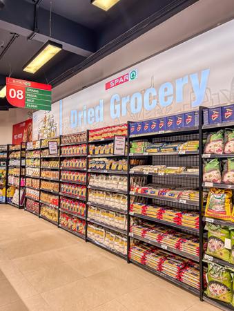 Una amplia selección de espaguetis y arroz exhibidos en un supermercado.