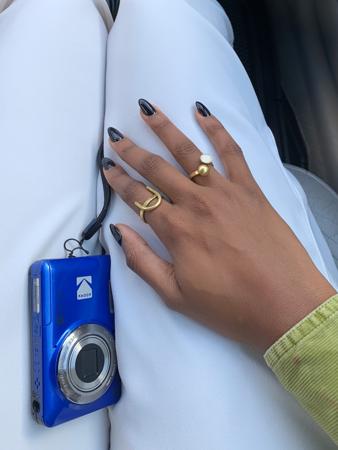 Mkono wenye pete za kifahari kando ya kamera ya bluu