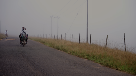 Motorcyclists on a foggy road in the countryside