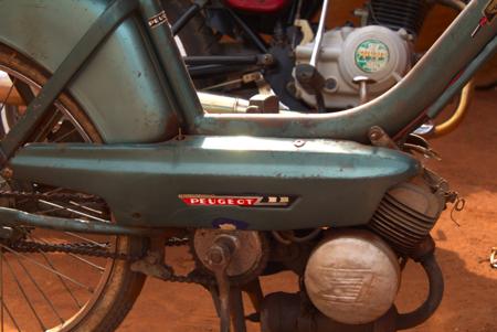 Detalhe de uma motocicleta Peugeot 103 vintage em solo ocre