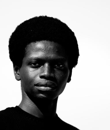 Black and white portrait of a young man with frizzy hair 