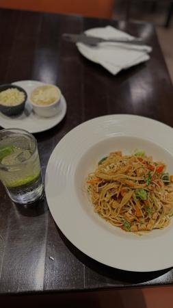 Un plat de Spaghetti  accompagné d'un verre de boisson