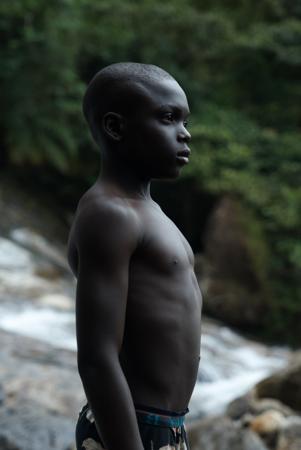 A young man at the water's edge in a tropical area