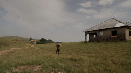 A person walks towards a rural house