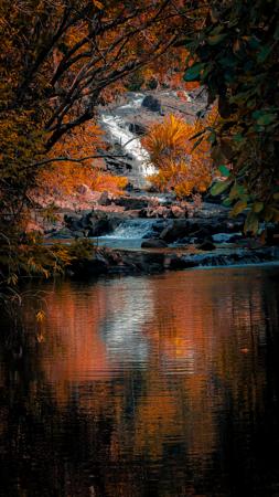 Rocky waterfall, enveloped by the flamboyant autumn forest at Kundelungu Park 